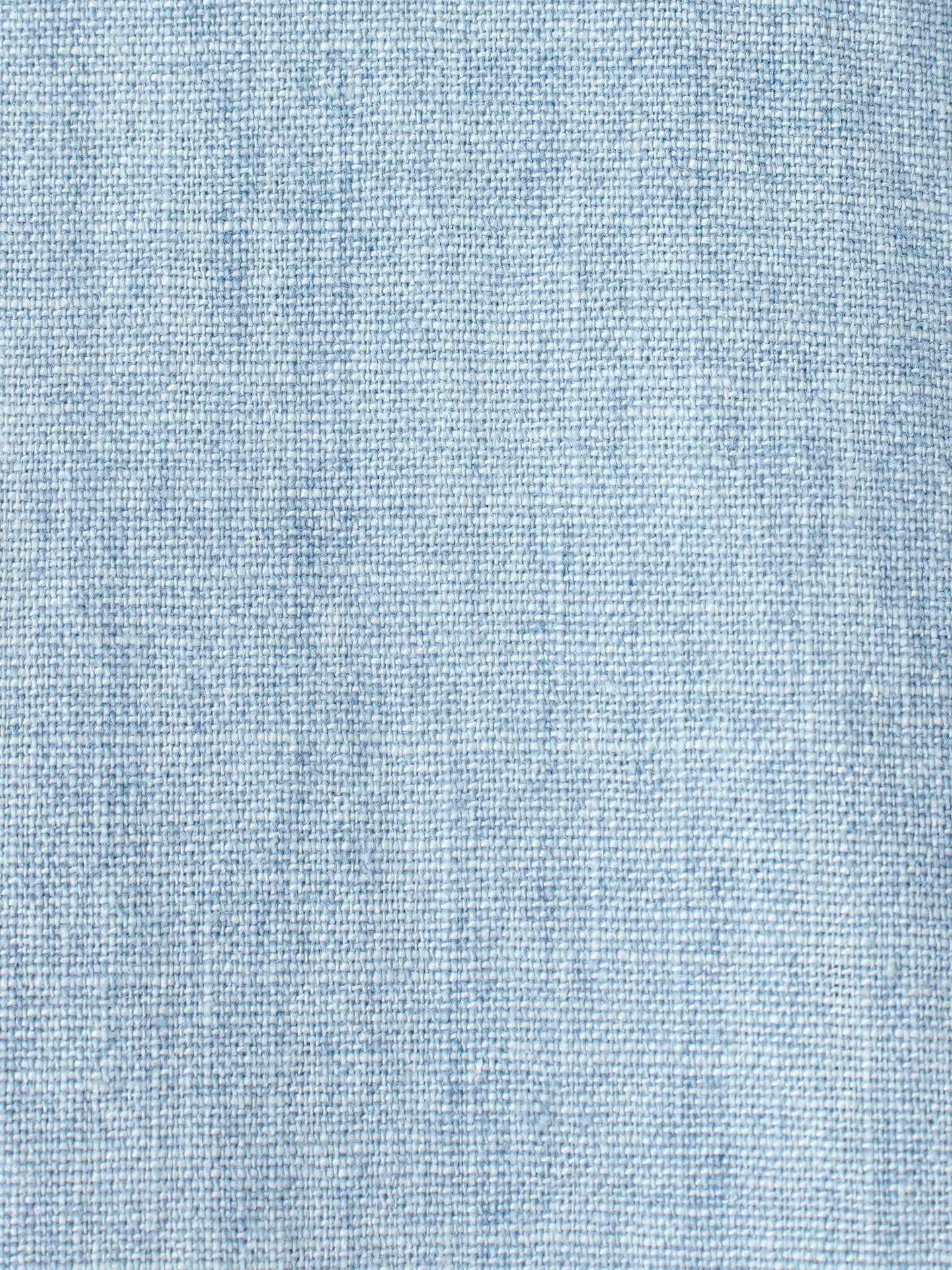 Close-up of a Griffen Shirt by Xirena, featuring light blue denim fabric with a subtle texture akin to lightweight cotton chambray. Its weave pattern and varied shades evoke the classic look of Western-inspired casual shirts and jeans.