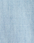 Close-up of a Griffen Shirt by Xirena, featuring light blue denim fabric with a subtle texture akin to lightweight cotton chambray. Its weave pattern and varied shades evoke the classic look of Western-inspired casual shirts and jeans.