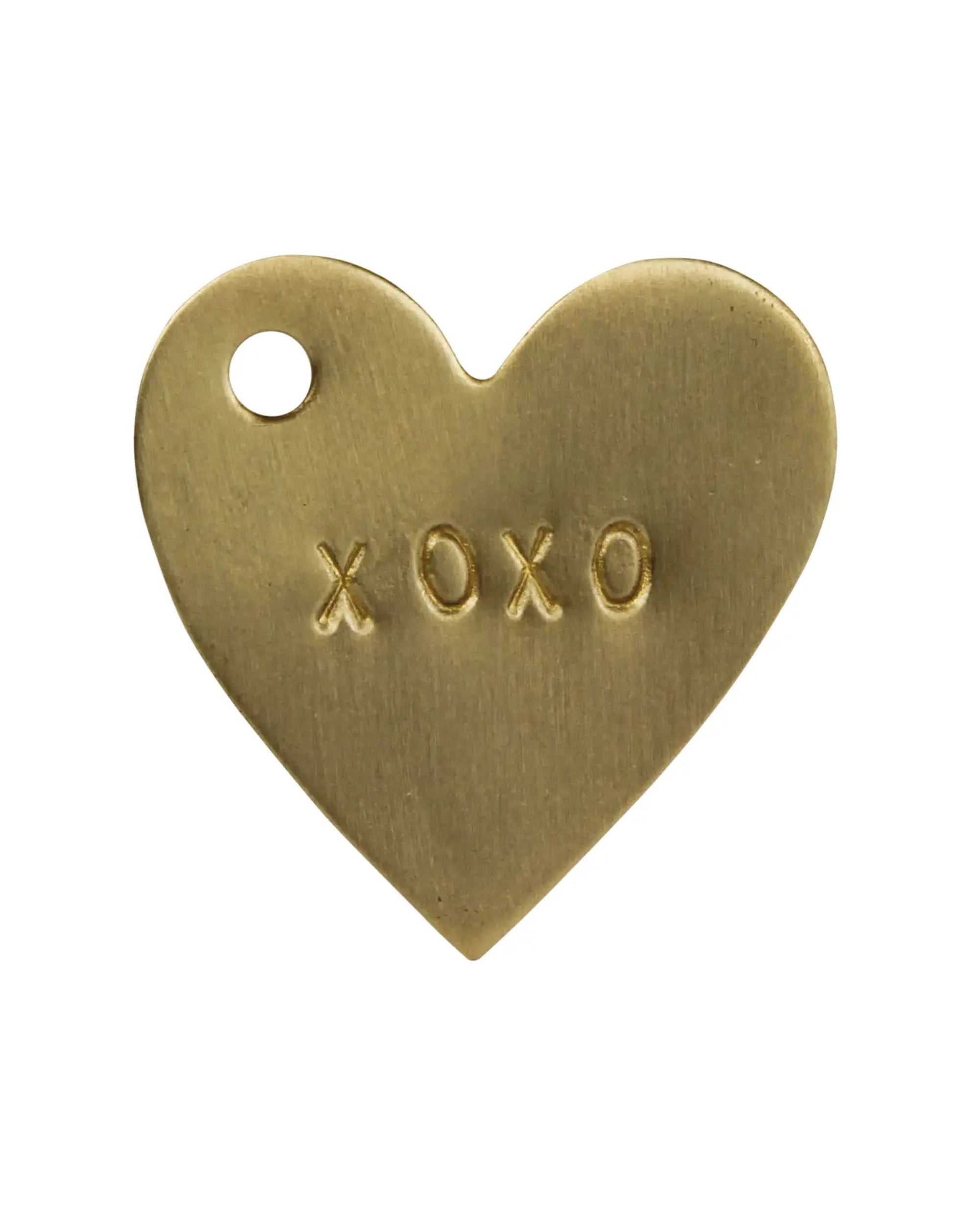 The HomArt Brass Tag XOXO is a hand-stamped, heart-shaped brass tag with a small hole at the top left and "XOXO" engraving—ideal as a unique gift tag or sentimental present.