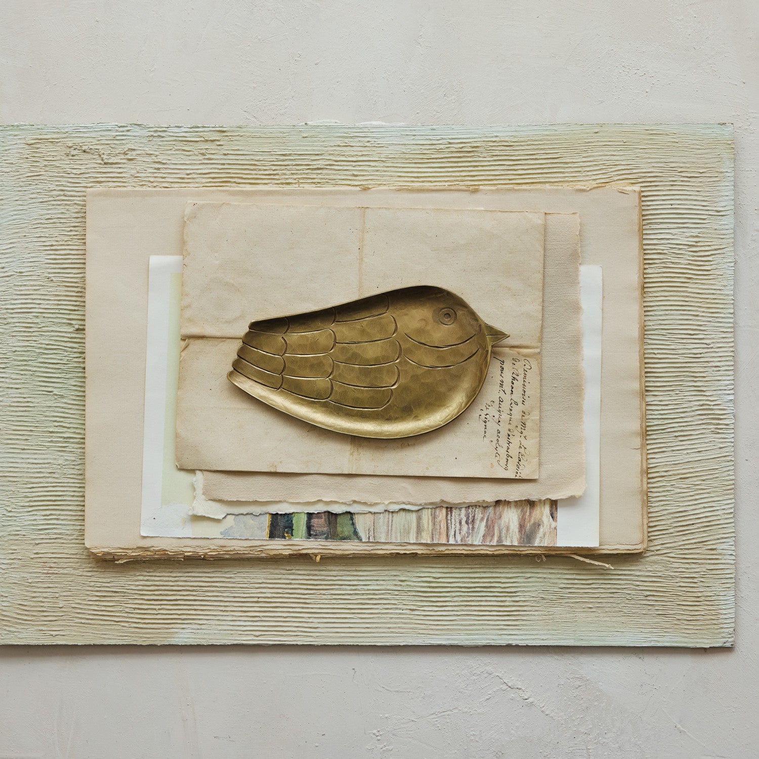 Bird-shaped Creative Co-op XT0218 tray displayed on vintage papers with a neutral textured background.