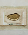 Bird-shaped Creative Co-op XT0218 tray displayed on vintage papers with a neutral textured background.