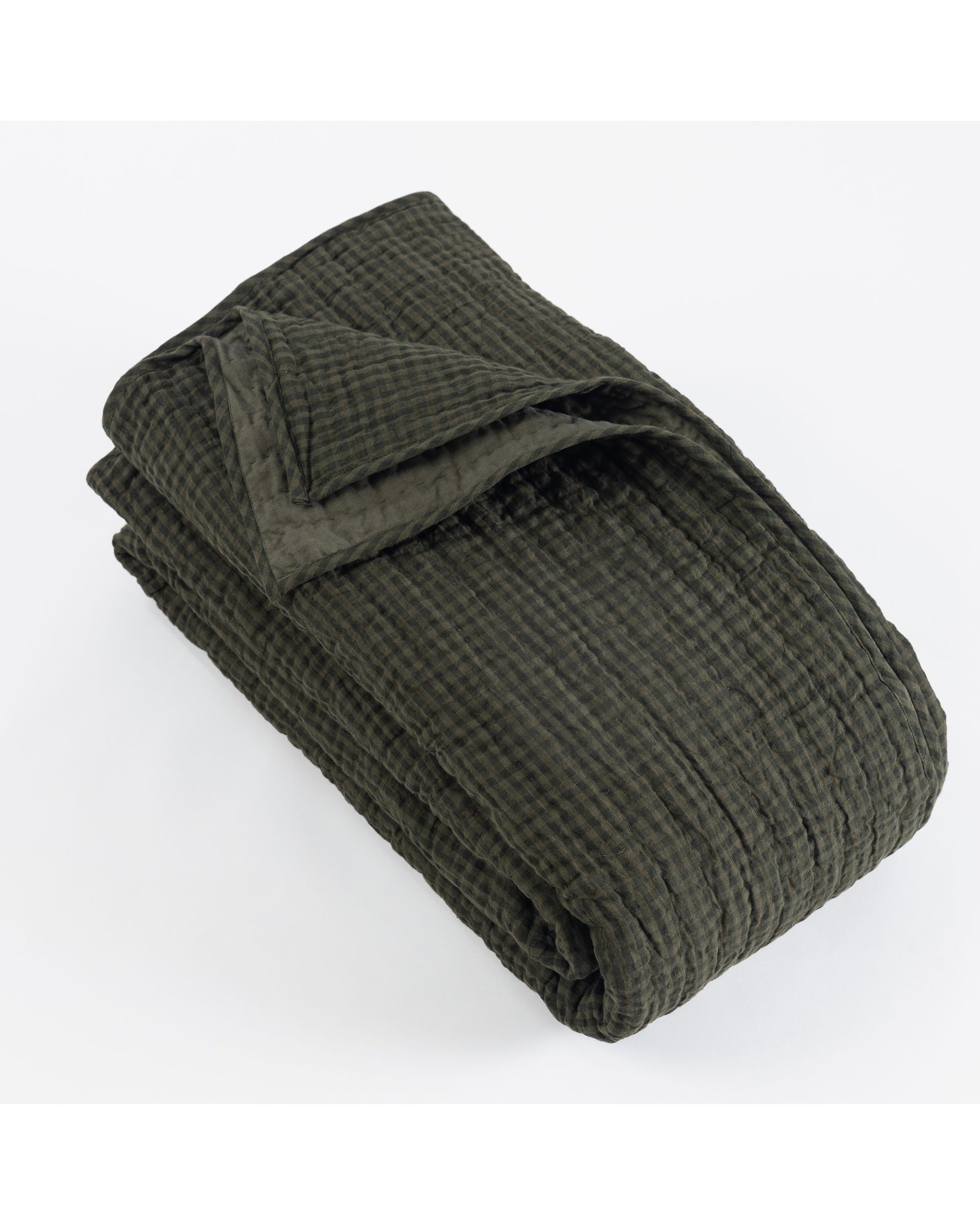The Zane Quilt by Amity Home, in dark cypress green with a quilted texture, is neatly folded and displayed against a plain white background.