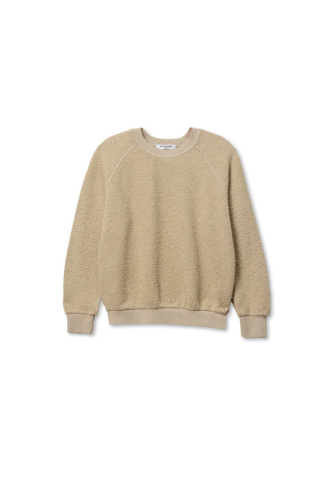 The Ziggy Reverse LS Sweatshirt by Perfectwhitetee is a beige, shrunken-fit crewneck with bracelet-length sleeves and ribbed cuffs, hem, and neckline, crafted from textured fleece-like fabric. Shown laid flat on a white background.