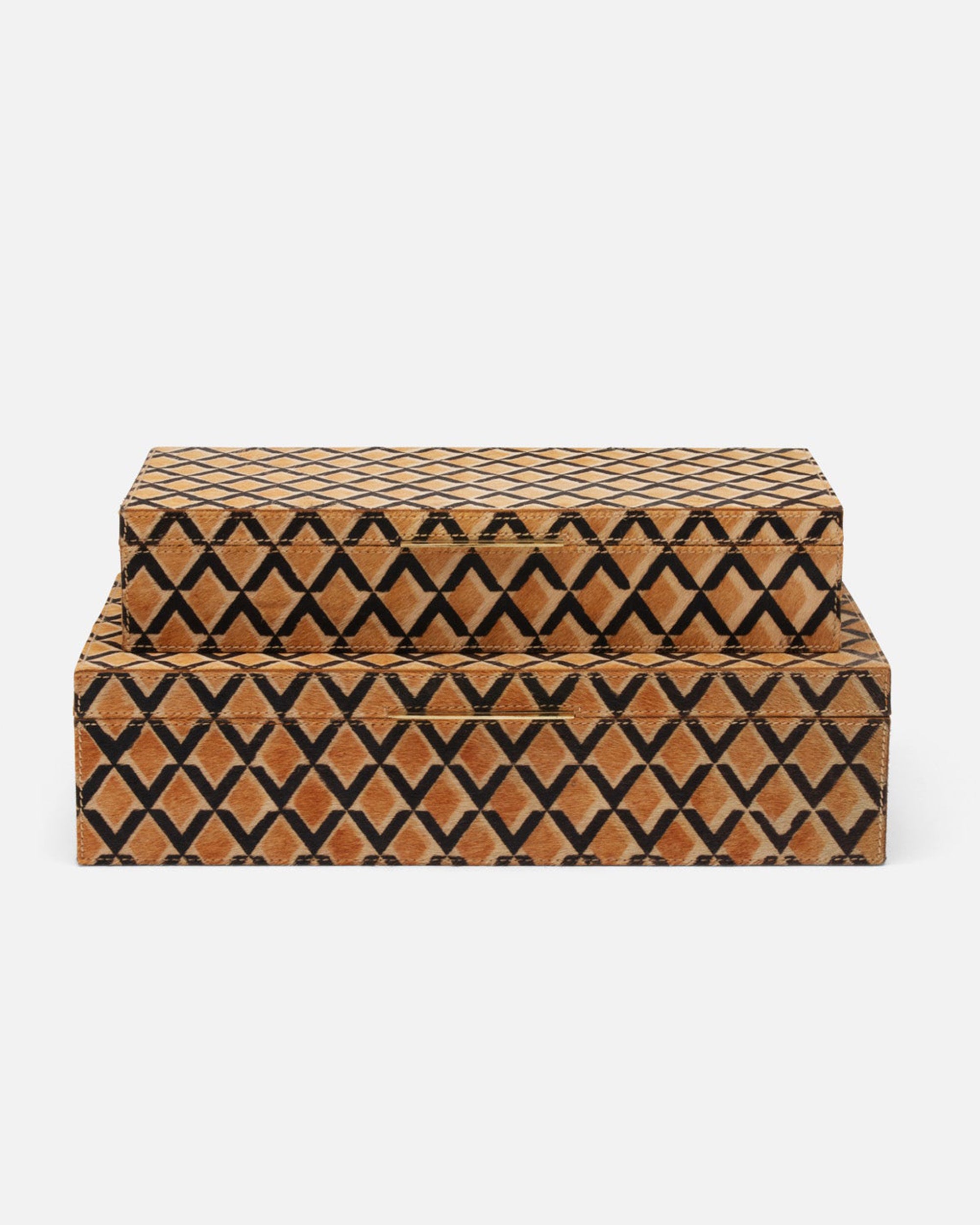 Two Zion Hair on Hide Boxes by Made Goods, stacked, feature lids and a geometric scalloped black pattern on brown hair-on-hide for natural texture.