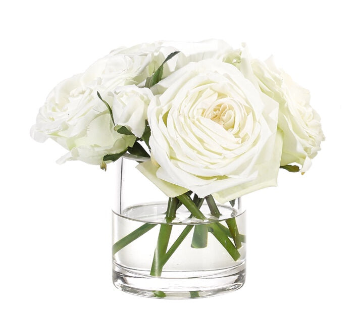 A bouquet of fresh White Watergarden roses displayed in a clear glass vase against a white background in a Scottsdale, Arizona bungalow.