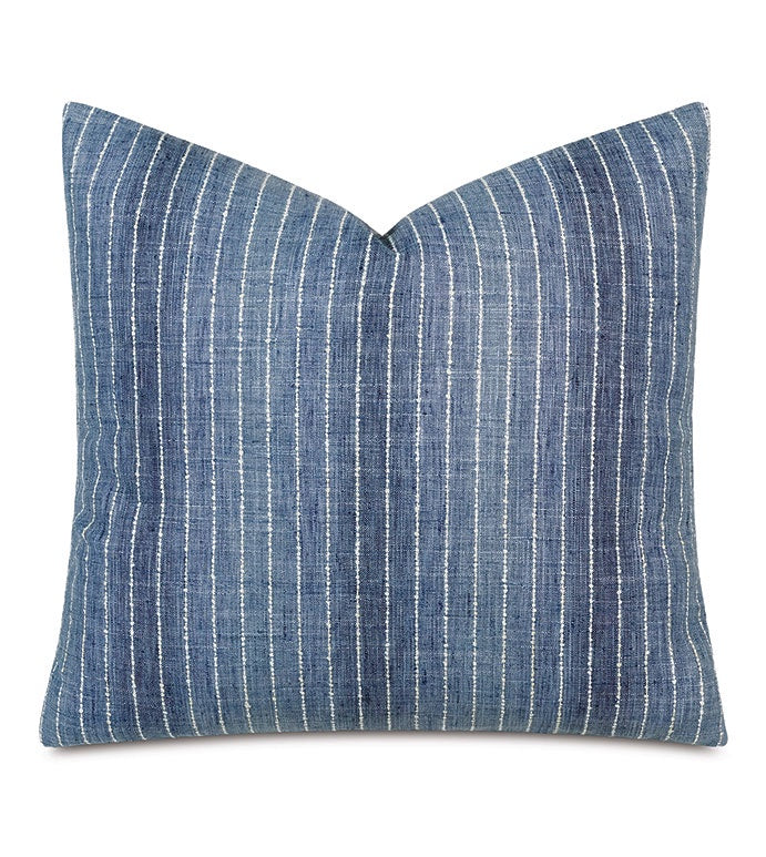Blue denim pillow with white vertical stripes on a neutral background, perfect for a Scottsdale, Arizona bungalow. The Kasama Striped 22x22&quot; pillow by Eastern Accents is square-shaped with a slight curve at the edges, suggesting a soft, plush texture.