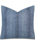 Blue denim pillow with white vertical stripes on a neutral background, perfect for a Scottsdale, Arizona bungalow. The Kasama Striped 22x22" pillow by Eastern Accents is square-shaped with a slight curve at the edges, suggesting a soft, plush texture.